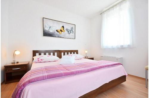 a bedroom with a large bed with a purple blanket at Apartments Bonsai in Podstrana