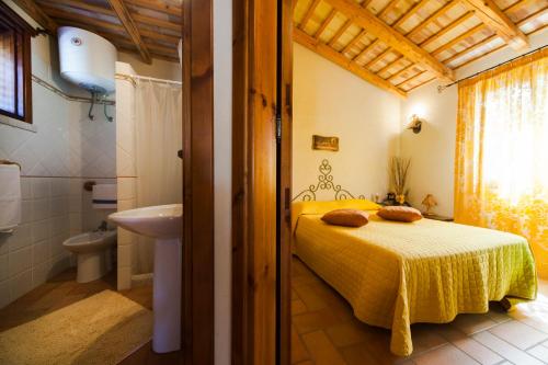 a bedroom with a yellow bed and a bathroom at case vacanza zingaro in San Vito lo Capo