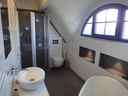 a bathroom with a sink and a shower and a toilet at Ferienhaus Seeraeuber in Vieregge