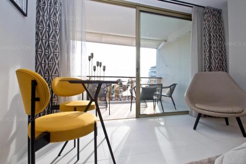 une salle à manger avec une table et des chaises jaunes dans l'établissement Khayat, à Cannes