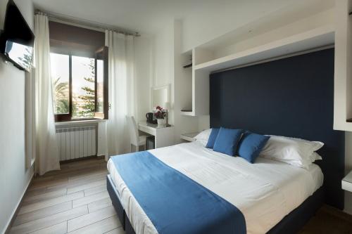 a bedroom with a large bed with a blue headboard at Central Plaza Sorrento Coast in Sant'Agnello