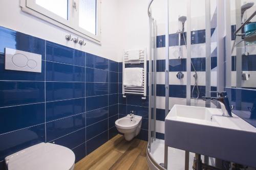 a blue and white bathroom with a toilet and a sink at Central Plaza Sorrento Coast in Sant'Agnello