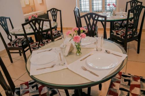 uma mesa com dois pratos e um vaso de flores em RAMAS GARDEN em Trivandrum