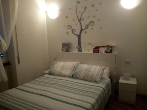 a bedroom with a bed with a tree on the wall at Appartamento a Viterbo in Viterbo