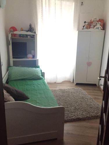 a bedroom with a bed with green sheets and a window at Appartamento a Viterbo in Viterbo