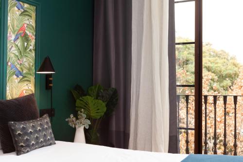 a bedroom with a bed and a balcony with a window at Casa Vaganto in Barcelona