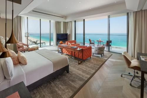 a hotel room with a balcony overlooking the ocean at Mandarin Oriental Jumeira, Dubai in Dubai