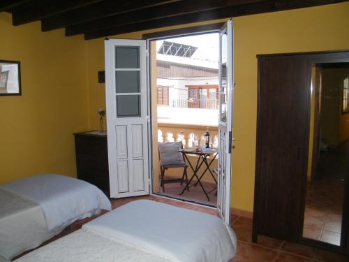 een slaapkamer met 2 bedden en een balkon met een tafel bij Casa Rural San Francisco in Granadilla de Abona