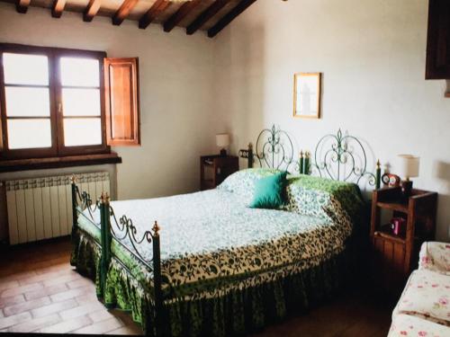 1 dormitorio con cama y ventana en Romantico Cottage, en Radicofani