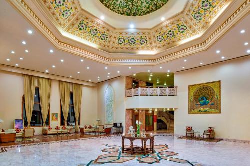 vestíbulo con techo artesonado y mesa en The Ummed Jodhpur Palace Resort & Spa, en Jodhpur