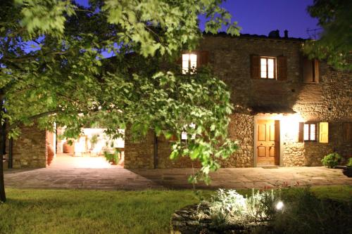 a stone house with a tree in front of it at Podere Fichereto Tuscany apartment in Florence countryside in Scandicci