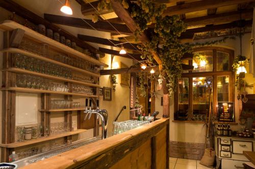 un bar avec un comptoir en bois et des verres sur les étagères dans l'établissement Gästehaus Bräuscheuere, à Homburg