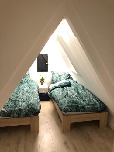 two beds in a room with a attic at No6a Luxe design appartement in historisch hart Dordrecht ALLES dichtbij! in Dordrecht