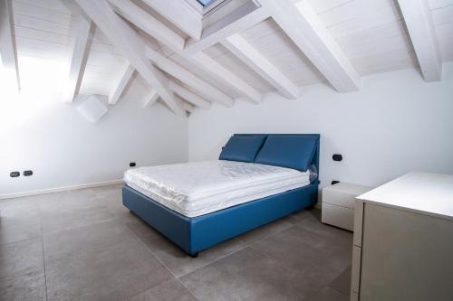 a bedroom with a blue bed and white ceilings at Lake Como Apartments in Lecco