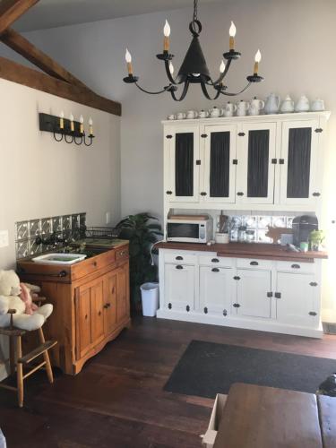 a kitchen with white cabinets and a sink at The Carriage House Flat - Downtown Paris Canada in Paris