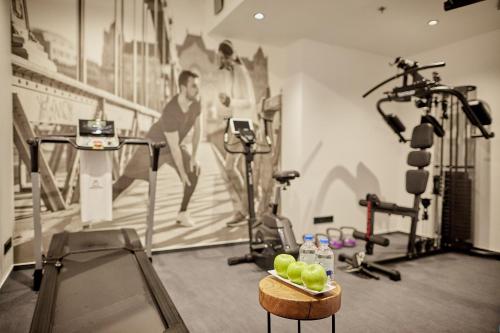 a gym with exercise equipment and a wall mural at Hotel Memories OldTown in Budapest