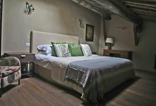 een slaapkamer met een bed met groene en witte kussens bij Stylish apartment in the historic center of Cortona in Cortona