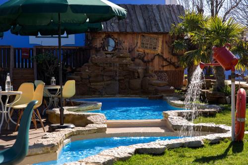 a swimming pool with a waterfall in a backyard at NINHO SALOIO in Venda do Pinheiro