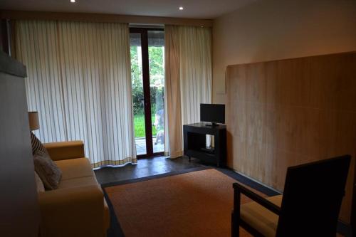 a living room with a couch and a tv at Quinta do Mosteiro in Felgueiras