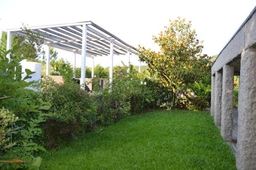a garden with a pergola and green grass at Quinta do Mosteiro in Felgueiras