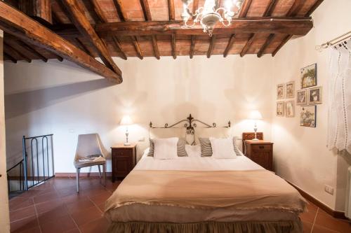 Un dormitorio con una cama grande en una habitación con techos de madera. en Borgo Solamore, en Cortona