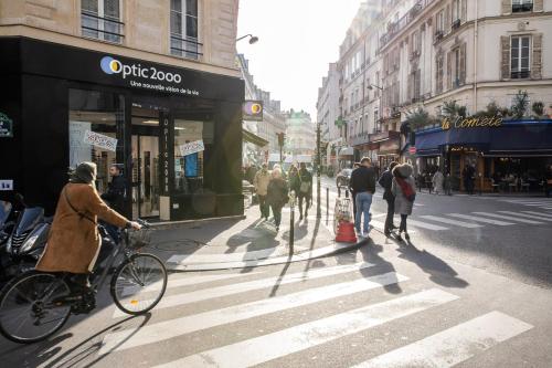 a person riding a bike on a city street at Villa Opera Drouot in Paris