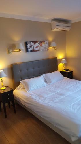 a bedroom with a large white bed with two lamps at Hotel Macchia e Mare in Pietracorbara
