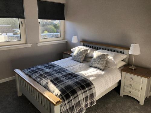 1 dormitorio con 1 cama y 2 ventanas en Old Police House Causewayhead Stirling en Stirling