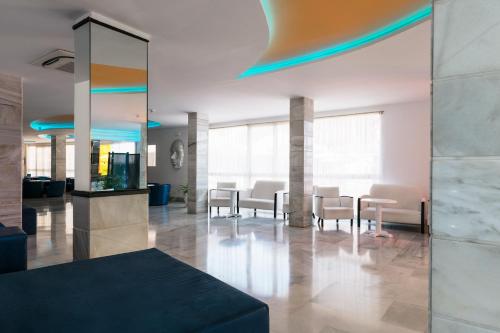 a lobby with tables and chairs in a building at Bellevue Vistanova in Magaluf