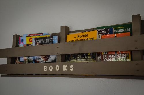 a wooden shelf filled with books on a wall at B&B Au Canard in La Roche-en-Ardenne