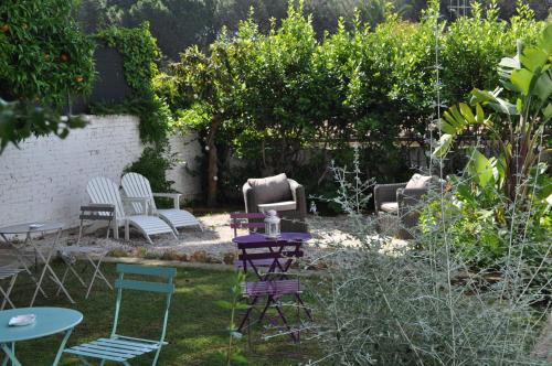 a garden with chairs and a table and chairs at Guerrini Hotel in Castiglioncello