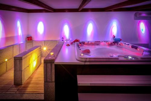 uma grande casa de banho com uma banheira com luzes roxas em Quinta do Olival em Vilas Boas