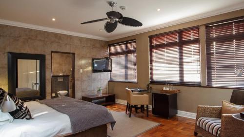 a bedroom with a bed and a desk and a television at Manor 38 in Port Elizabeth