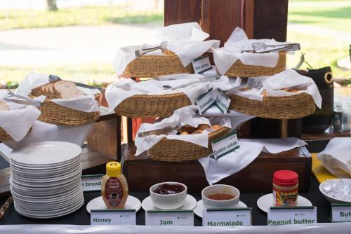 a table topped with baskets of bread and plates at Sunbird Nkopola in Chipoka