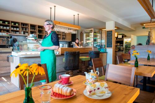 a woman in a green dress standing in a kitchen at Kürbishof Gartner in Fehring