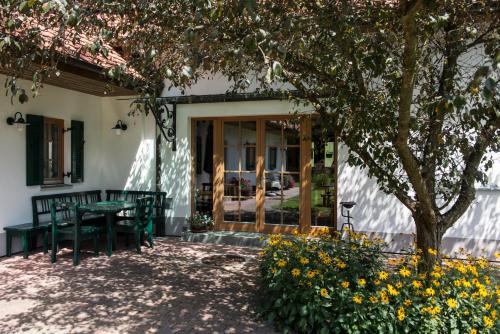 a patio with a table and chairs and a tree at Kürbishof Gartner in Fehring