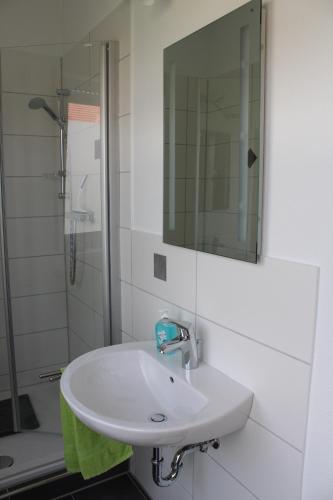 a white bathroom with a sink and a shower at Pension Boitz in Rust