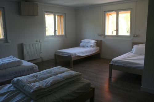 a room with three beds and two windows at Domaine de Maravant - Centre de vacances in Thollon