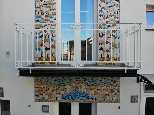 einen Balkon mit Mosaiken an der Seite eines Gebäudes in der Unterkunft Case Vacanza Le Casette in Santo Stefano di Camastra