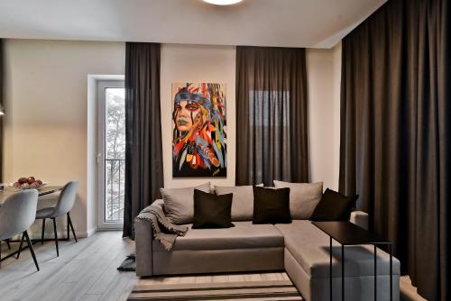 a living room with a couch and a painting at City Center loft 2 in Kaunas