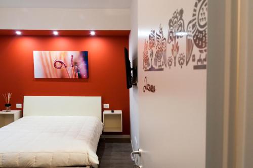 a bedroom with a white bed and an orange wall at VILLA FENIX PONTE SAN PIETRO in Ponte San Pietro