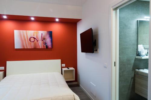 a bedroom with a white bed and a red wall at VILLA FENIX PONTE SAN PIETRO in Ponte San Pietro