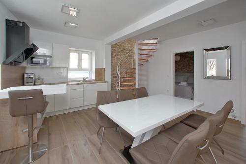 uma cozinha e sala de jantar com uma mesa branca e cadeiras em Villa Vito em Bibinje