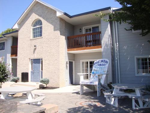 a house with a chair and a table in front of it at Put-in-Bay Poolview Condo #4 in Put-in-Bay