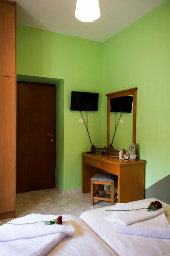 a green room with two beds and a desk and a mirror at Argoules House in Argoulés