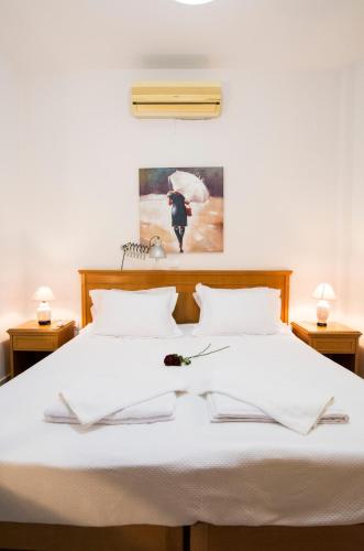 a bed with white sheets and a flower on it at Argoules House in Argoulés