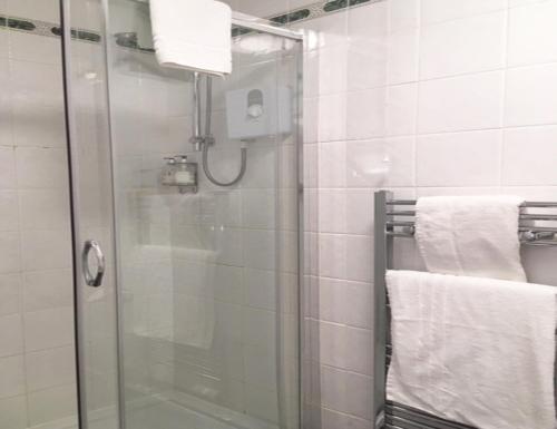 a bathroom with a shower with towels and a glass door at Leapark Hotel in Grangemouth