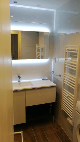 une salle de bain avec un lavabo et un miroir dans l'établissement Rêve bleu, au Grau-du-Roi