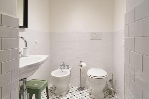 a white bathroom with a toilet and a sink at Casadina in Camaiore