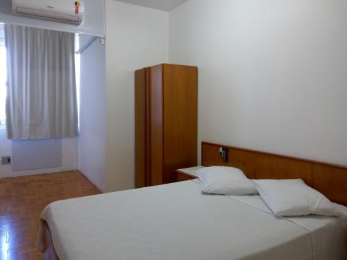 - une chambre avec un lit blanc et une fenêtre dans l'établissement City Hotel PF, à Passo Fundo